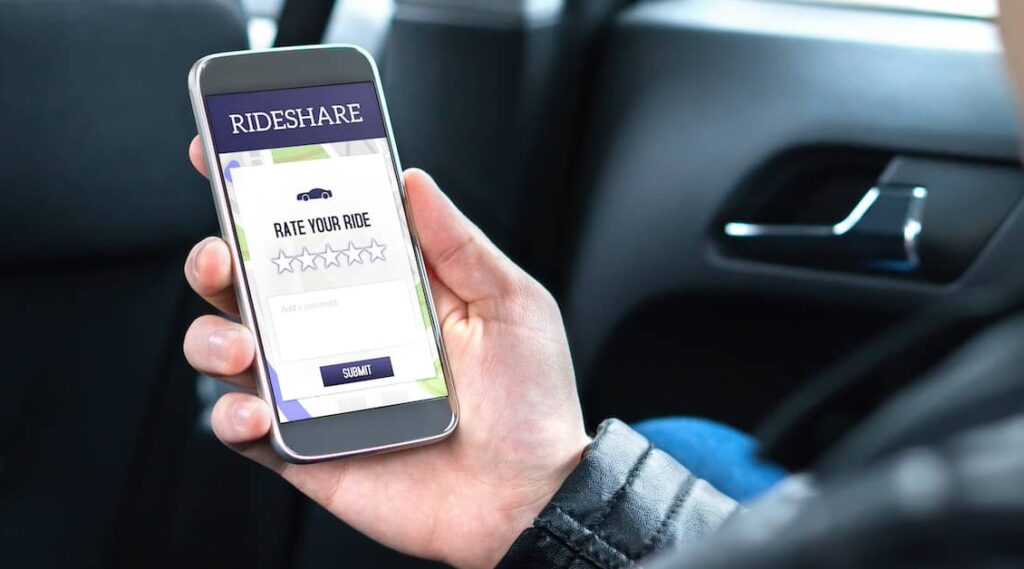 Rideshare driver checking the app on a mobile phone | Henry Carus + Associates
