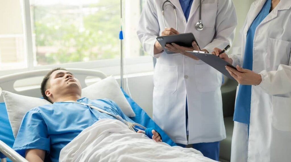 Doctors reviewing hospital patient's chart | Henry Carus + Associates