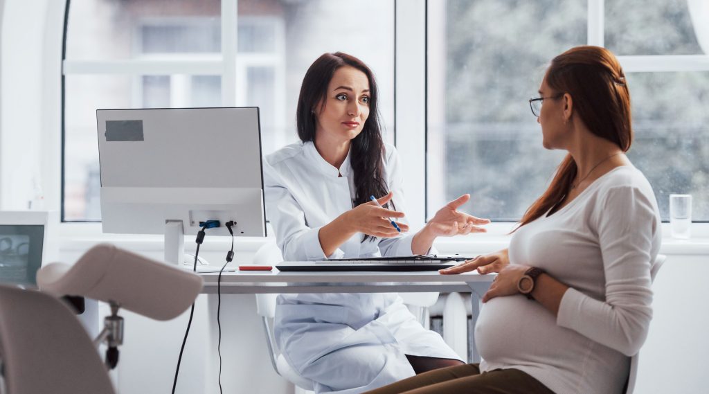 Pregnant woman reviewing information about home birth and hospital birth options during pregnancy.